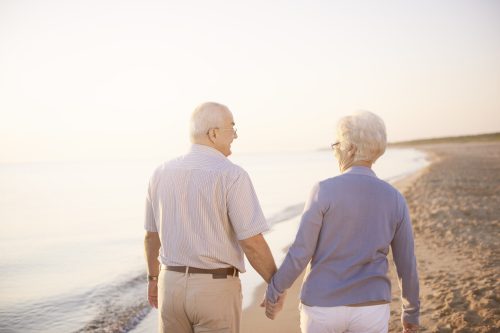 Holding hands while walking on the beach